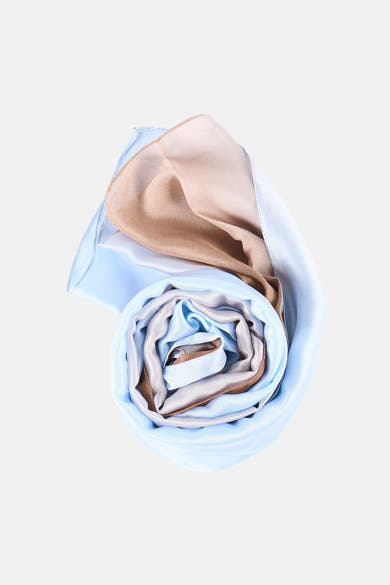 Foulard multicolore Access® enroulé, avec des nuances de bleu, beige et marron.