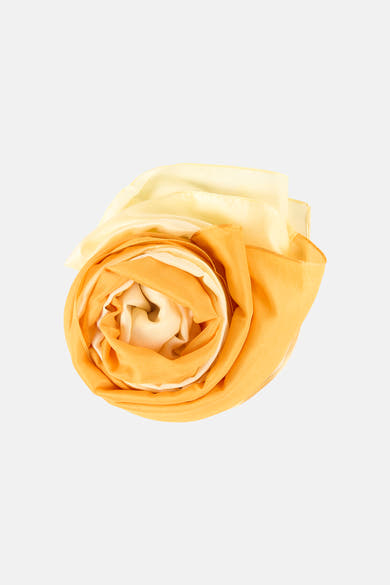 Foulard jaune Access® roulé, avec des nuances de couleurs plus claires, sur fond uni.
