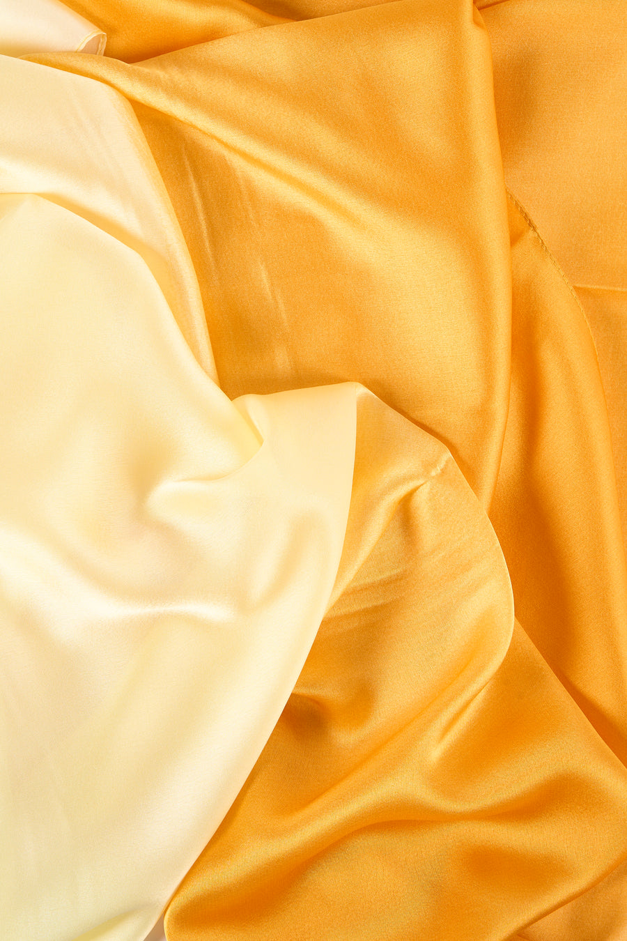 Foulard jaune Access® en tissu soyeux, avec des plis élégants et des nuances de couleur chaude.