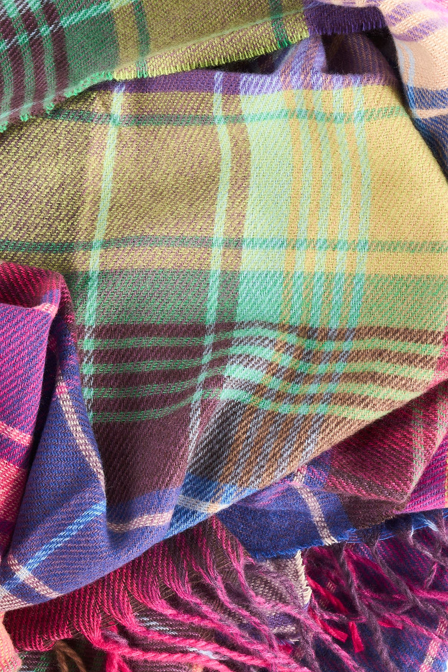 Gros plan sur un foulard Access® multicolore à carreaux, avec des franges.