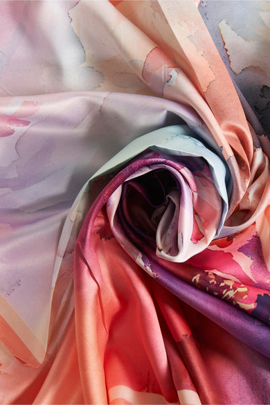 Foulard multicolore de Access® avec des motifs floraux abstraits dans des tons rose, violet et pêche.