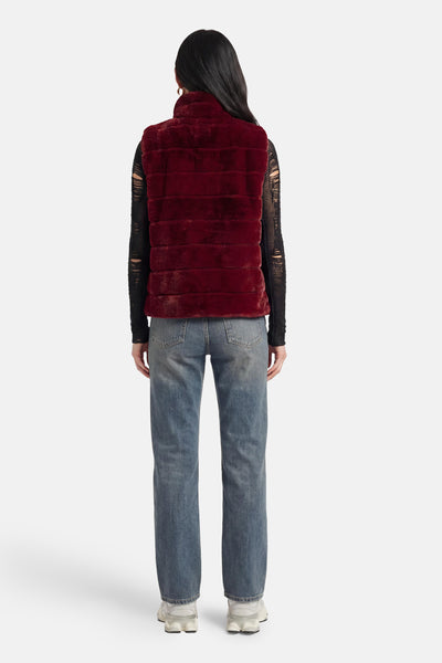 Veste sans manches rouge de Access® en fausse fourrure à côtes horizontales, vue de dos, portée sur un haut noir déchiré.
