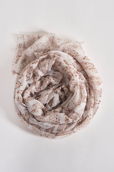 Beige voile sjaal van Access®, met een gespikkeld textuurpatroon, in spiraalvorm gerangschikt.
