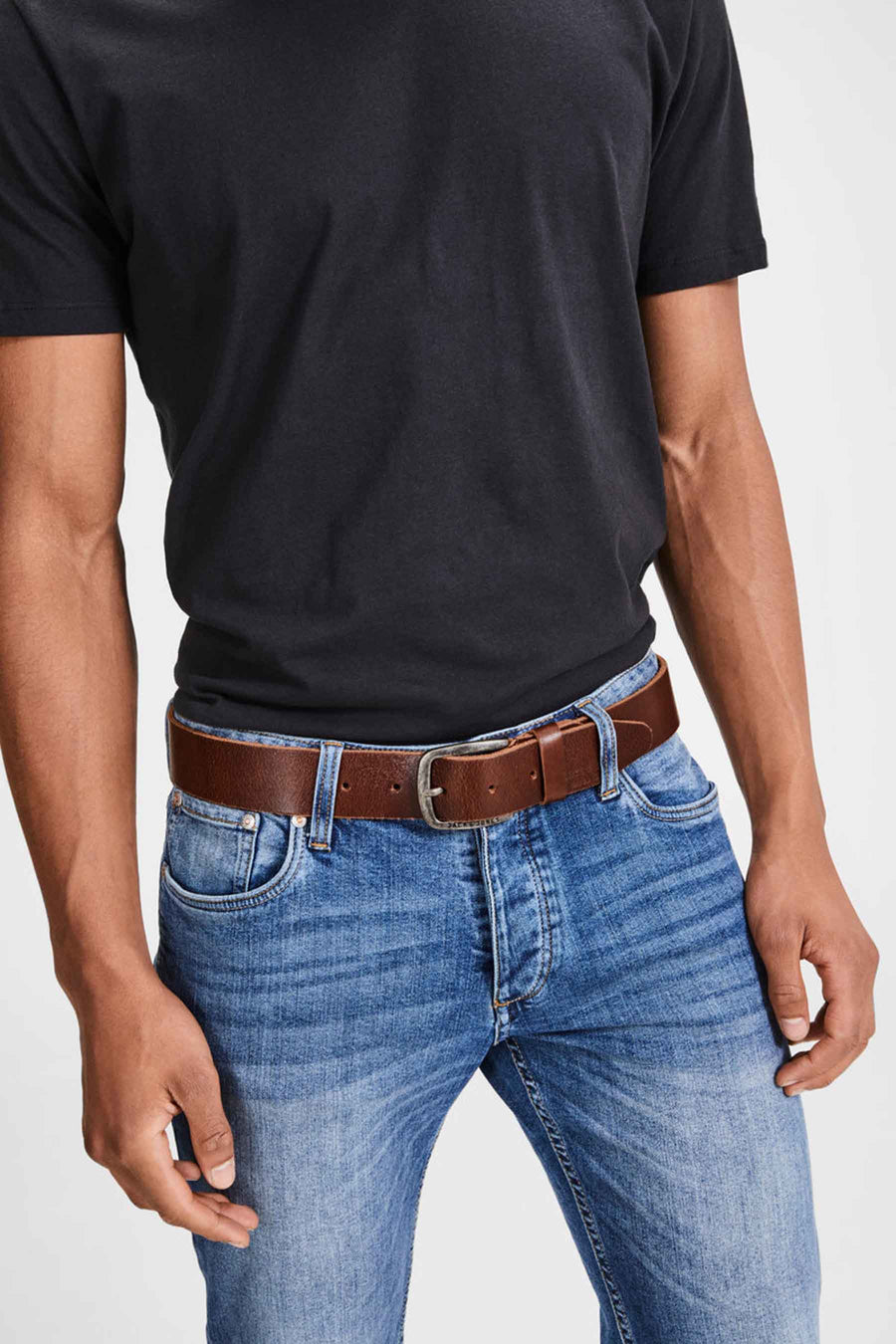 Ceinture marron en cuir de ACCESSORIES BY JACK & JONES, portée avec un jean bleu et un t-shirt noir.