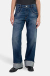 Jean large en denim bleu foncé par Le Temps des Cerises, avec revers et chaussures vernies noires.
