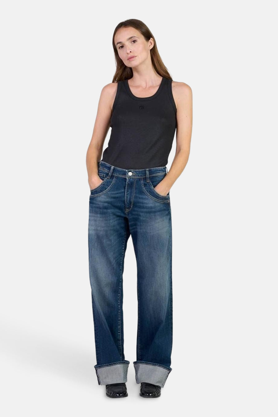 Jean large en denim bleu foncé de Le Temps des Cerises, porté avec un débardeur noir.
