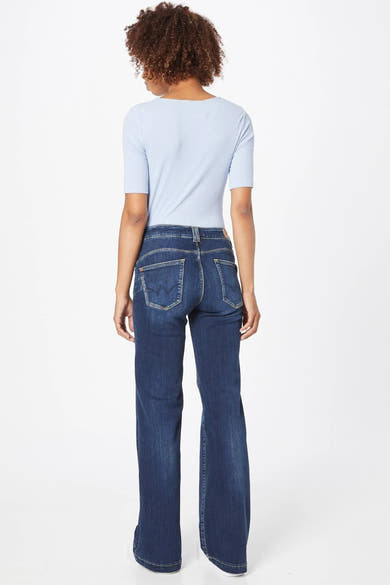 Jean évasé bleu de Le Temps des Cerises, coupe classique, porté avec un t-shirt bleu clair.