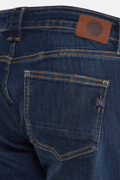 Jean évasé en denim bleu foncé de Le Temps des Cerises, avec poche arrière et patch logo en cuir.