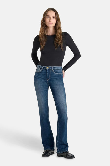 Middelblauwe bootcut jeans van Le Temps des Cerises, gedragen met een zwart shirt met lange mouwen en zwarte schoenen.