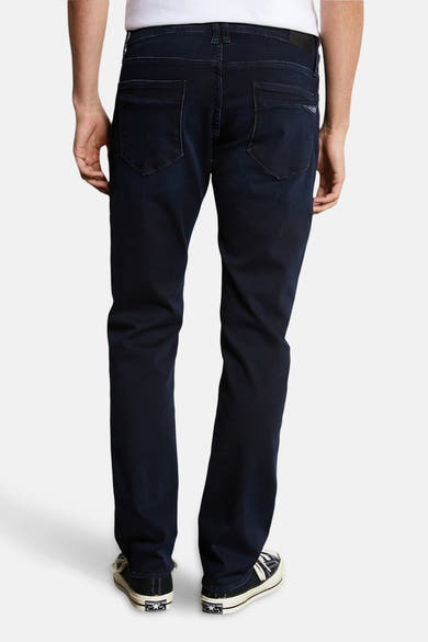 Rechte zwarte denim jeans van Le Temps des Cerises, met achterzakken en zwart-witte schoenen.