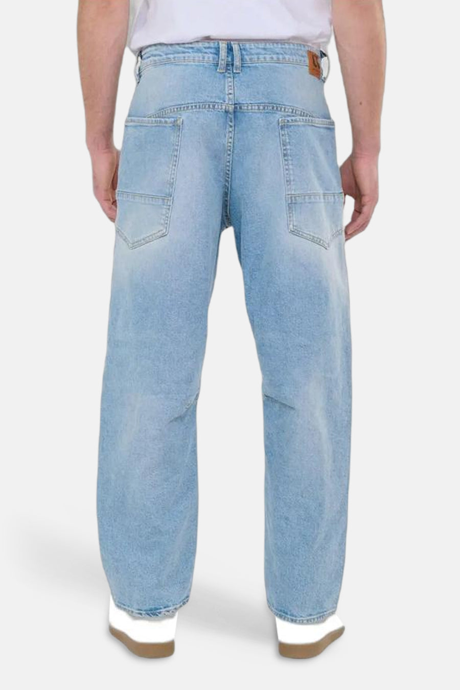 Wijde spijkerbroek in lichtblauw denim van Le Temps des Cerises, met vierkante achterzakken en witte schoenen.