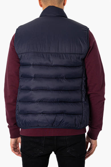 Veste sans manches bleue de LYLE & SCOTT, portée sur un pull bordeaux et un jean noir, vue de dos.