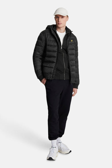 Veste courte noire de LYLE & SCOTT, portée avec un t-shirt blanc et un pantalon de survêtement noir.