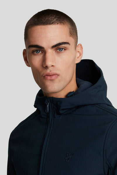 Blauwe regenjas van LYLE & SCOTT, met capuchon en ritssluiting op een neutrale grijze achtergrond.