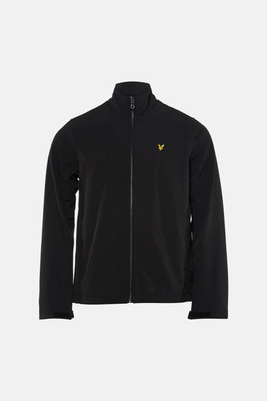 Zwarte regenjas van LYLE & SCOTT gedragen met een gescheurde spijkerbroek en sneakers.