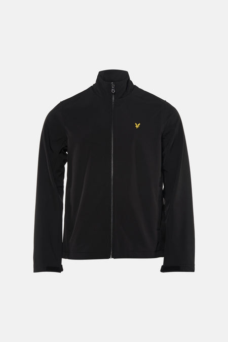 Zwarte regenjas van LYLE & SCOTT gedragen met een gescheurde spijkerbroek en sneakers.
