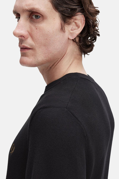 Zwarte rondehals trui van FRED PERRY, in textuurgebreid met geborduurd logo op de voorkant.