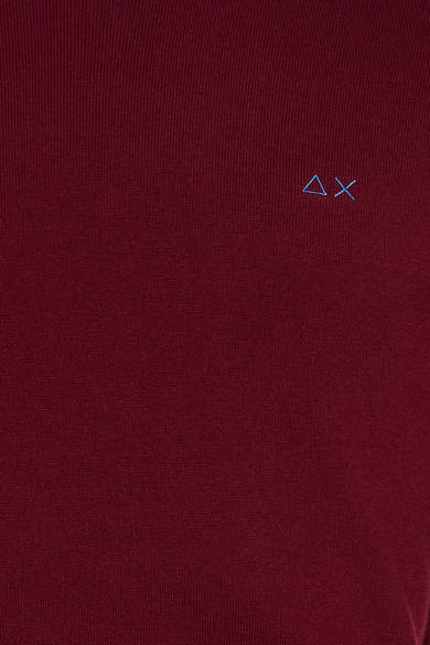 Red O-neck sweater with fine knit texture and small blue embroidered logo on chest, close-up view