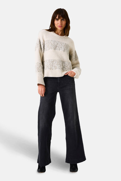 Beige ronde hals trui van GARCIA, met horizontale strepen met zilveren accenten, gedragen met een wijde zwarte jeans.