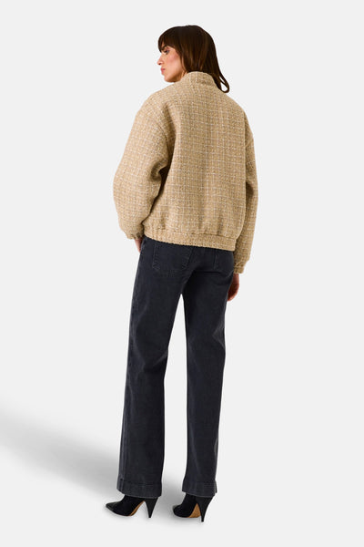 Korte beige jas van GARCIA, met textuurpatroon, gedragen met een donkere jeans en zwarte enkellaarsjes.
