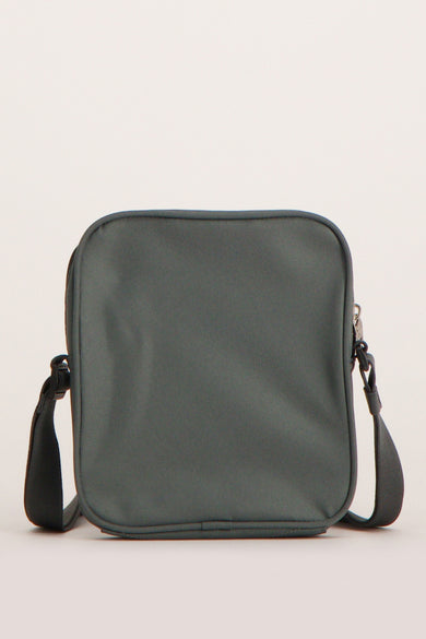 Sac à bandoulière gris de Calvin Klein, avec une bandoulière noire et une fermeture éclair argentée.
