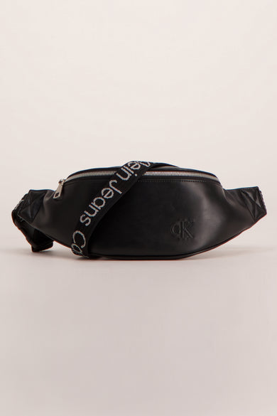 Sac banane noir en similicuir de Calvin Klein, avec une bandoulière portant l'inscription de la marque.
