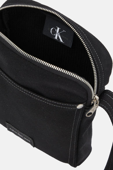 Zwarte schoudertas van Calvin Klein Jeans met zilverkleurige ritssluiting en stikseldetails.