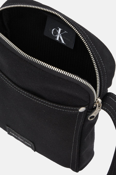 Zwarte schoudertas van Calvin Klein Jeans met zilverkleurige ritssluiting en stikseldetails.
