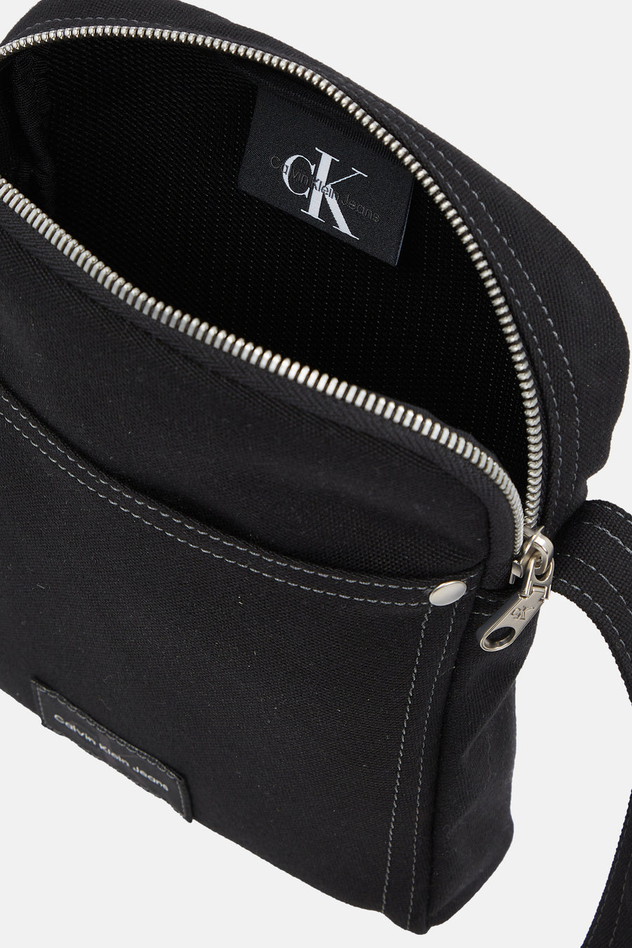 Zwarte schoudertas van Calvin Klein Jeans met zilverkleurige ritssluiting en stikseldetails.