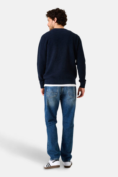 Donkerblauwe trui met ronde hals van GARCIA, met wafelstructuur, gedragen met een casual spijkerbroek en witte sneakers.