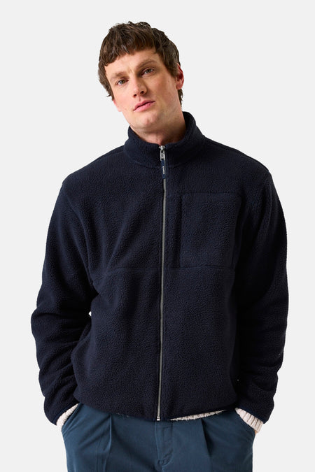 Marineblauwe fleece van GARCIA, met ritssluiting en opgestikte zak aan de voorkant, gedragen met een marineblauwe broek.