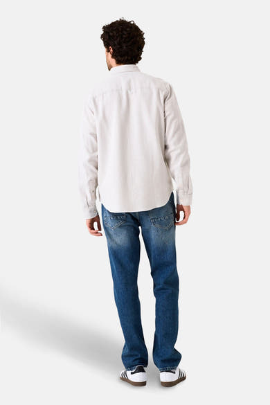 Beige overhemd met lange mouwen van GARCIA, van achteren gezien, gedragen met een spijkerbroek en witte sneakers met strepen.