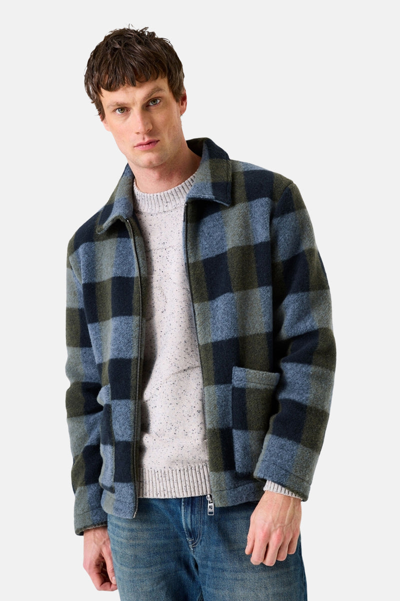 Veste à carreaux bleu et vert de GARCIA, portée sur un pull en maille, avec un jean.