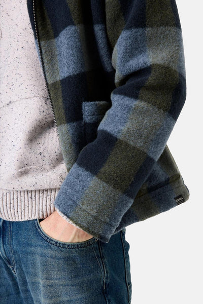 Veste en denim bleu moyen de GARCIA, à carreaux, portée sur un pull moucheté et un jean.