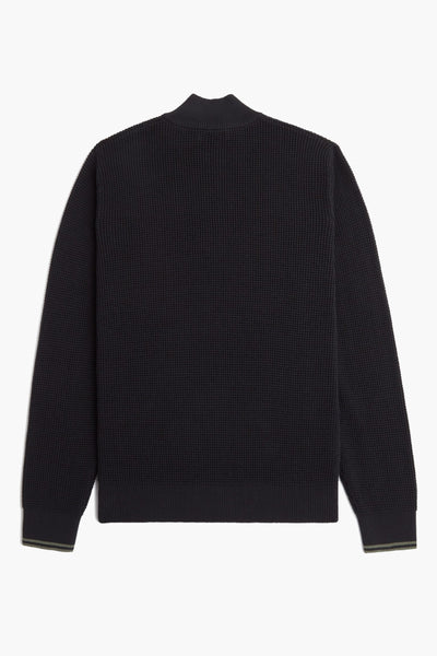 Pull à col roulé noir de Fred Perry, avec une texture gaufrée et des finitions côtelées aux poignets.