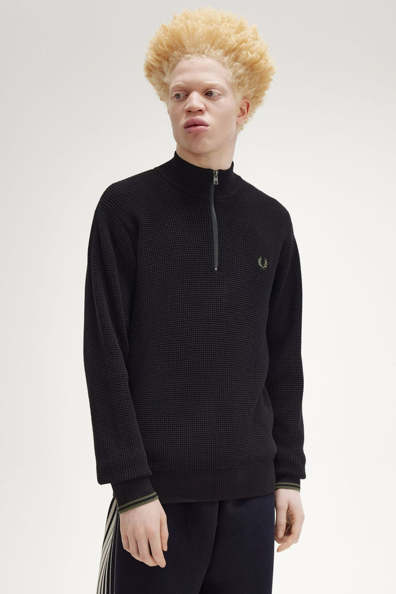 Pull à col roulé noir de Fred Perry avec fermeture éclair et logo laurier.