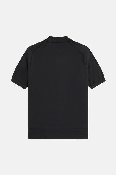 Polo noir par Fred Perry, avec manches courtes et une texture tricotée visible.