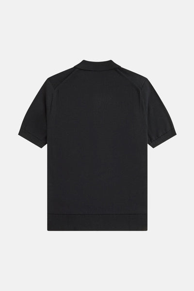Polo noir par Fred Perry, avec manches courtes et une texture tricotée visible.