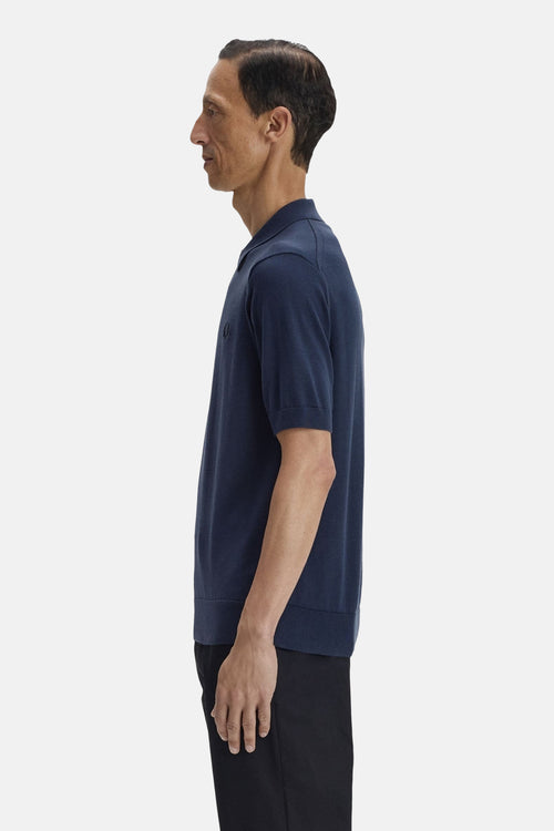 Blauw poloshirt met korte mouwen van FRED PERRY, gedragen met een zwarte broek, zijaanzicht.