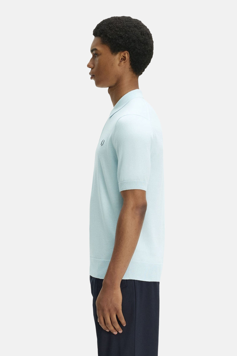 Polo en maille bleu clair de FRED PERRY avec col, manches courtes et logo brodé, vu de profil.