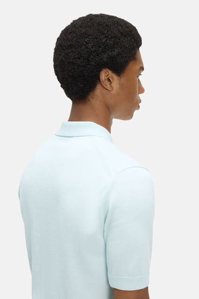 Polo en maille bleu clair de FRED PERRY, à manches raglan courtes, col et poignets côtelés, vu de dos et de profil.