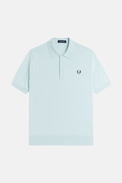 Polo tricoté bleu pâle de FRED PERRY, avec col, patte à trois boutons et logo couronne de laurier brodé.