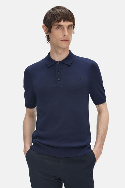 Donkerblauwe polo met korte mouwen van Fred Perry, met geborduurd logo op de borst en knoopsluiting.