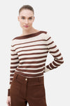Pull à col rond multicolore de CAROLL, à rayures horizontales marron et crème, porté avec un pantalon marron.