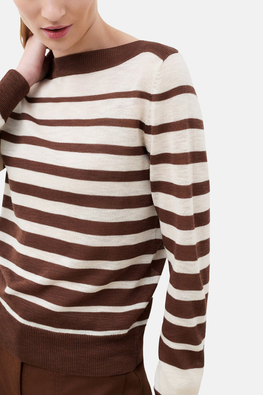 Pull à col rond multicolore de CAROLL, à rayures marron et écru, porté avec un pantalon assorti.