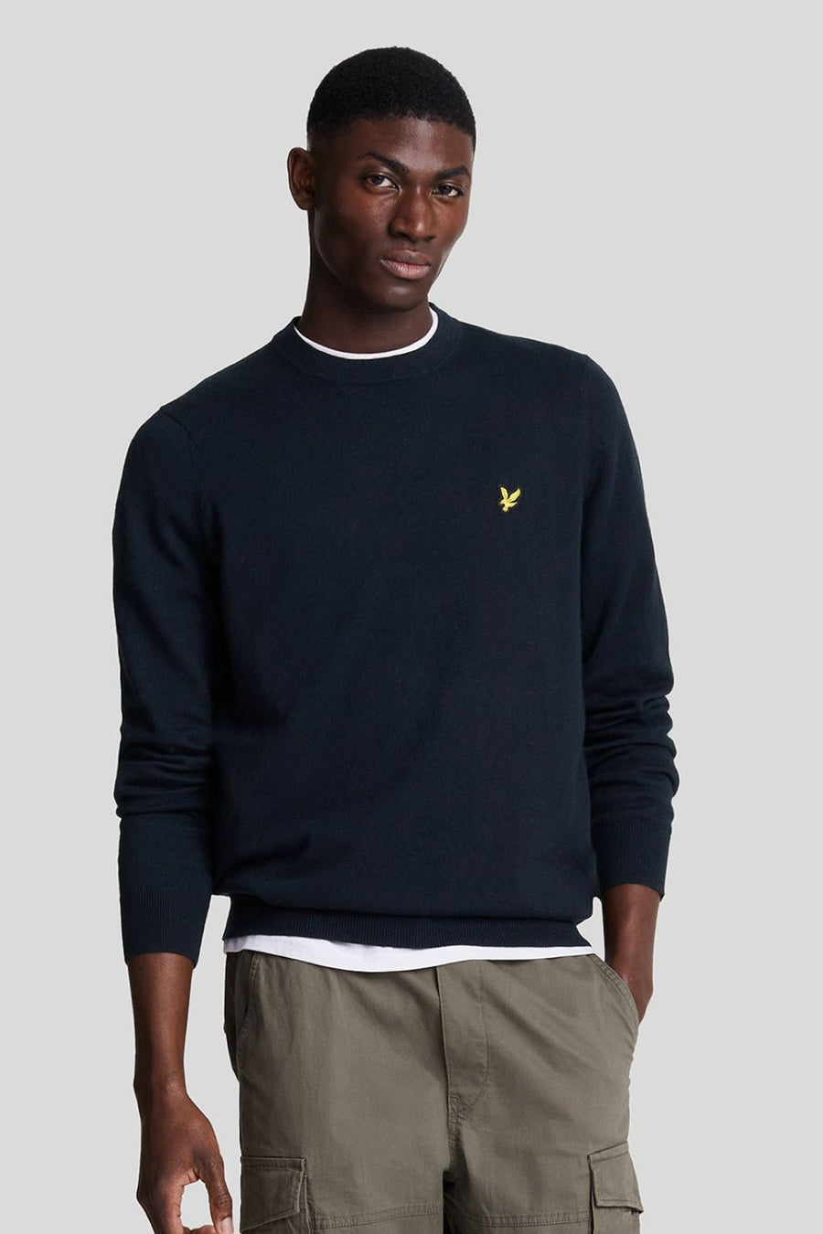 Ronde hals trui blauw van LYLE & SCOTT, gedragen met een olijfgroene cargobroek, achtergezicht.