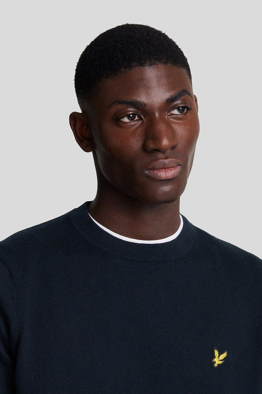 Navyblauwe rondehals trui van LYLE & SCOTT, met een geborduurd geel logo op de borst.