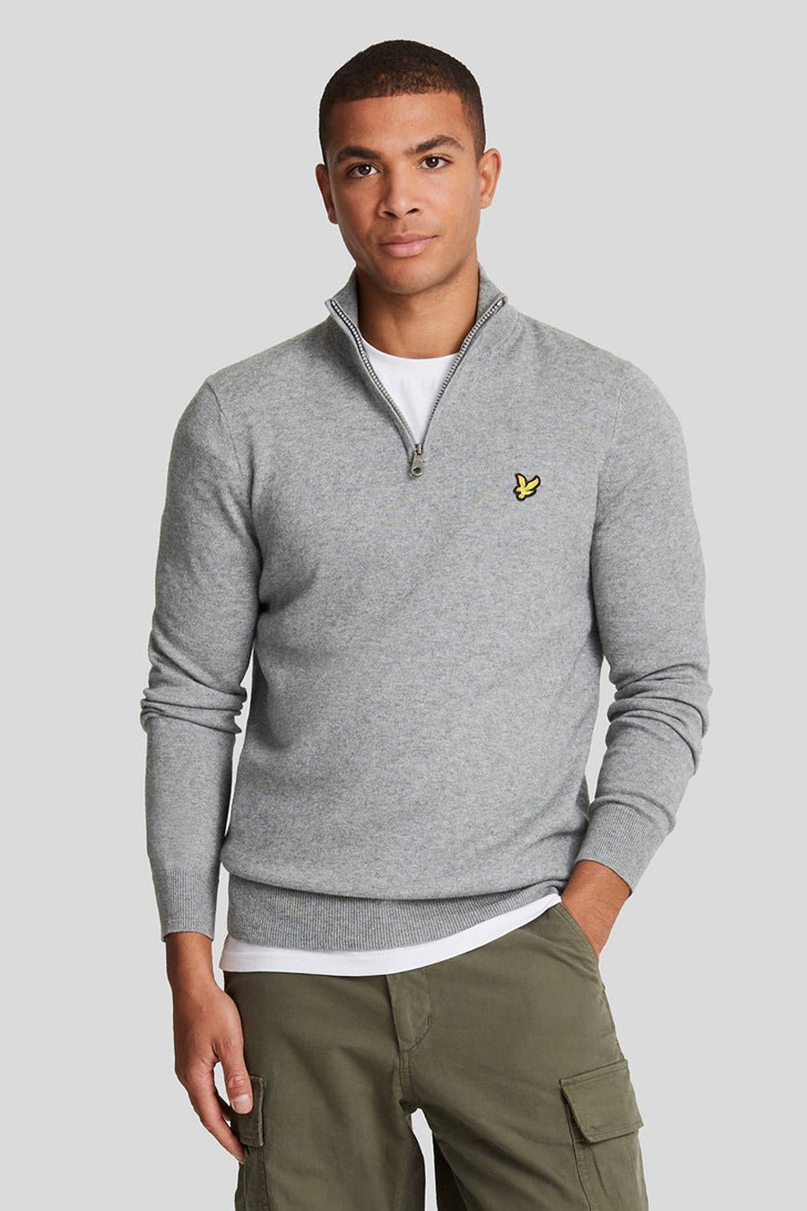 Grijze coltrui van LYLE & SCOTT, gedragen met een wit T-shirt en een olijfgroene cargobroek, achtergezicht.