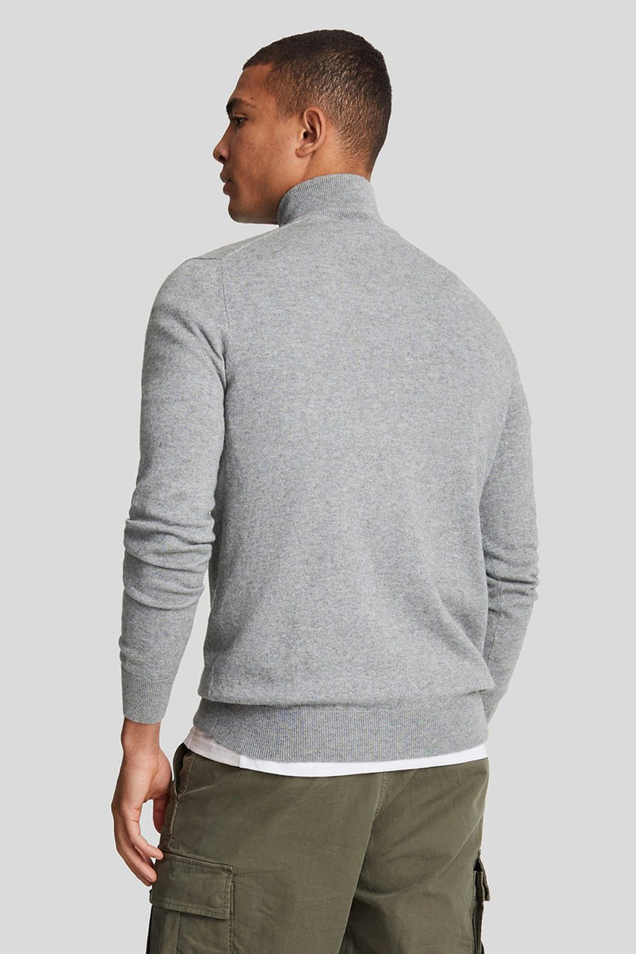 Pull à col roulé gris de LYLE & SCOTT, porté avec un t-shirt blanc et un pantalon cargo vert olive, vue de dos.