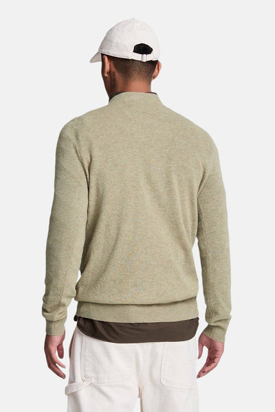 Pull à col rond vert de LYLE & SCOTT, porté avec un t-shirt marron et un pantalon écru, vue de dos.